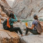 Hiking - a group of people sitting on top of a rock