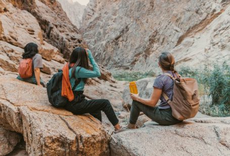 Hiking - a group of people sitting on top of a rock