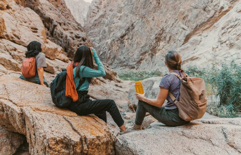Hiking - a group of people sitting on top of a rock