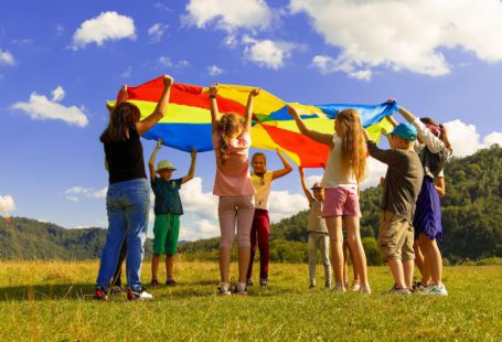 Kids Fun - group of women standing on green grass field during daytime