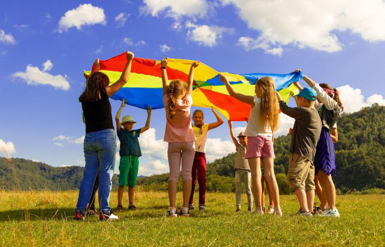 Kids Fun - group of women standing on green grass field during daytime