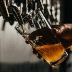 Craft Beer - person pouring brown liquid on clear drinking glass