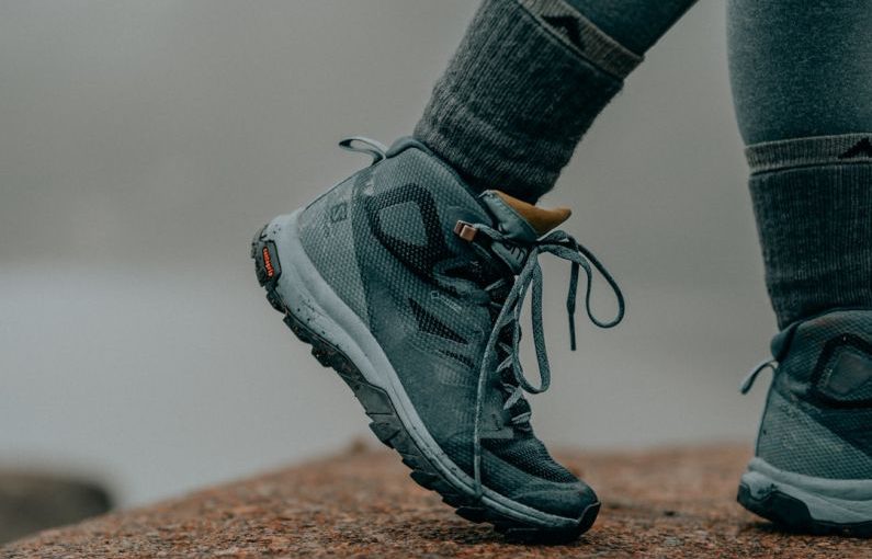 Hiking Boots - person in gray nike running shoes