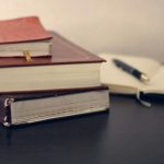 Law Book - selective focus photography of three books beside opened notebook