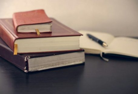 Law Book - selective focus photography of three books beside opened notebook