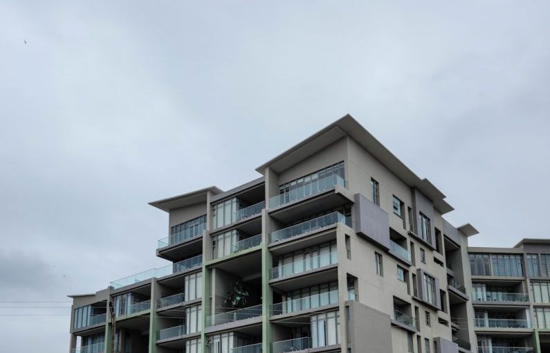 Shopping District - an apartment building with balconies and balconies on the second floor