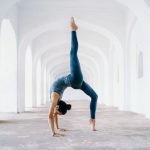 Yoga Pose - woman in blue leggings and black tank top doing yoga