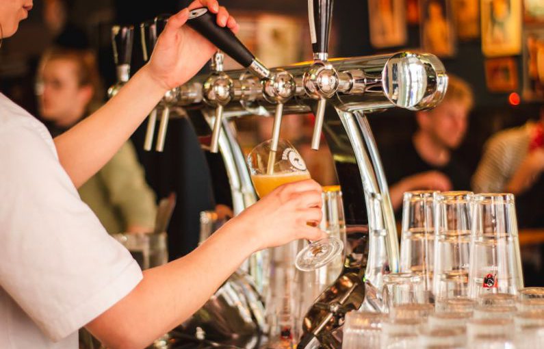 Brewery - person holding handle of faucet