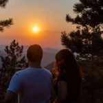 Romantic View - a man and woman kissing in front of a sunset