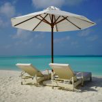Vacation Rental - white and brown beach umbrella on white sand beach during daytime