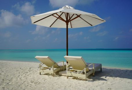 Vacation Rental - white and brown beach umbrella on white sand beach during daytime