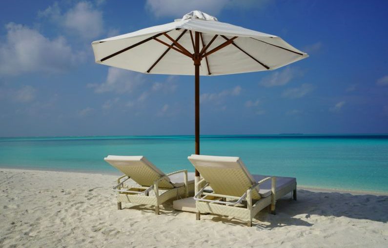 Vacation Rental - white and brown beach umbrella on white sand beach during daytime