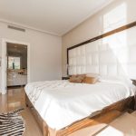 Hostel Room - brown wooden bed frame with white cover beside brown wooden nightstand