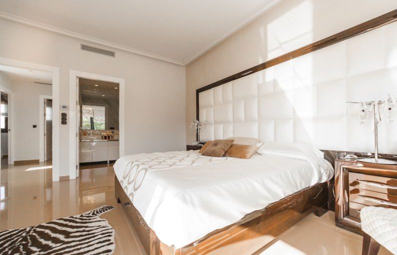 Hostel Room - brown wooden bed frame with white cover beside brown wooden nightstand