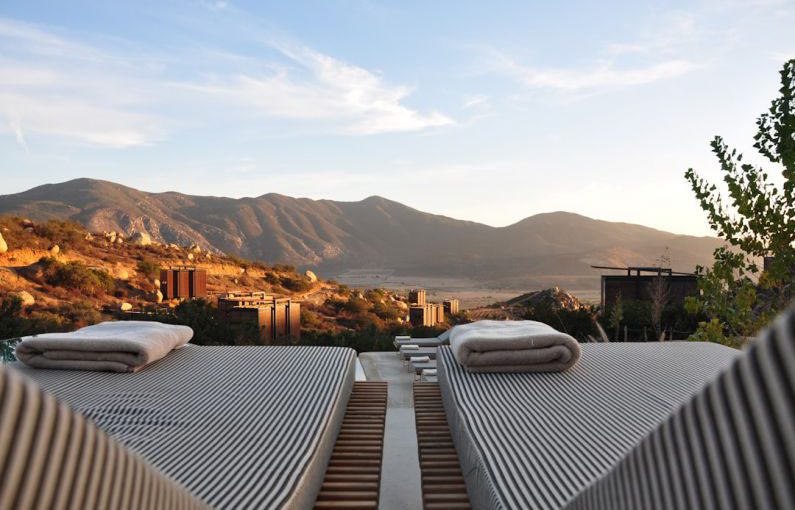 Boutique Hotel - sunloungers fronting buildings near mountain