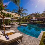 Family Hotel - white and brown lounge chairs beside swimming pool during daytime