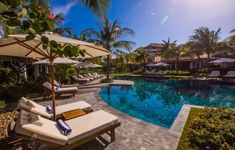 Family Hotel - white and brown lounge chairs beside swimming pool during daytime