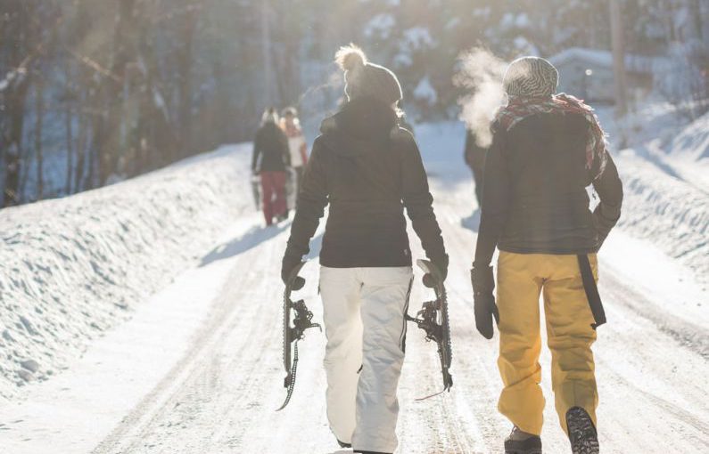 Apres-ski - person holding snow ski blades while walking on snowy mountain during daytime