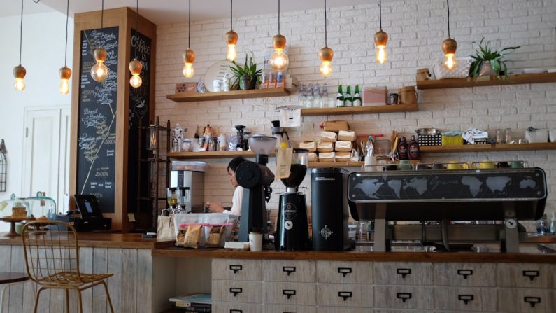 Coffee Shop - black kitchen appliance on kitchen island with pendant lights