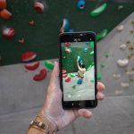 Indoor Fun - a person taking a picture of a climbing wall