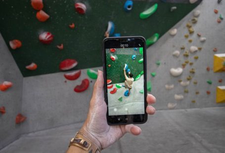 Indoor Fun - a person taking a picture of a climbing wall