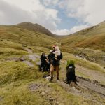 Day Trip - a group of people sitting on a rock with a dog
