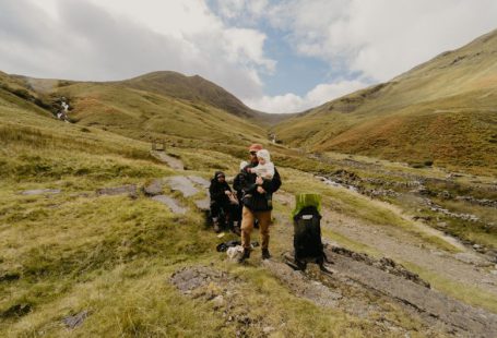Day Trip - a group of people sitting on a rock with a dog