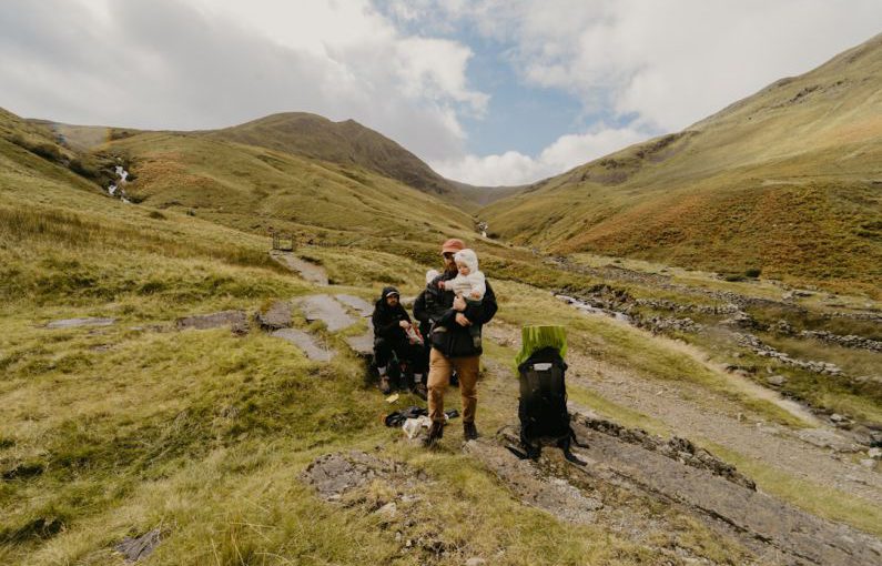 Day Trip - a group of people sitting on a rock with a dog