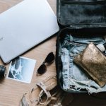 Suitcase - black DSLR camera near sunglasses and bag