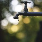 Water Tap - tilt shift lens photography of black steel faucet